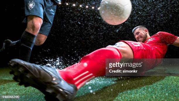 voetbalspeler proberen te glijden pakken zijn tegenstander - tackling stockfoto's en -beelden