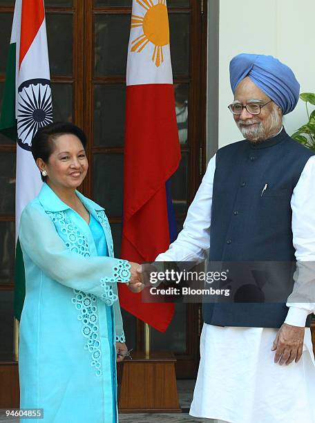 Manmohan Singh, right, India's prime minister, and Philippine's president Gloria Macapagal-Arroyo, shake hands at Hyderabad House prior to their...