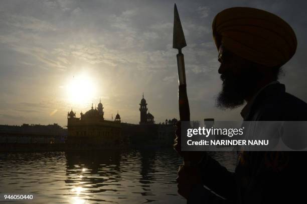An Indian Sikh sewadar volunteer stands on the occasion of Baisakhi festival at the Golden Temple in Amritsar on April 14, 2018. Baisakhi, also known...