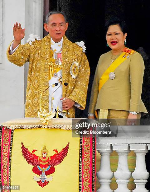 Thai King Bhumibol Adulyadej waves after giving a speech to nearly 1 million Thais as he stands with his wife, Queen Sirikit, on the balcony of the...