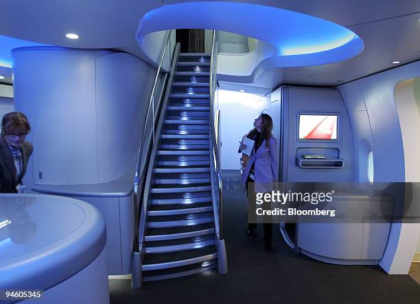 Boeing employees and media representatives tour the entry with the stair leading to the second level of the life-size display of the interior of the...