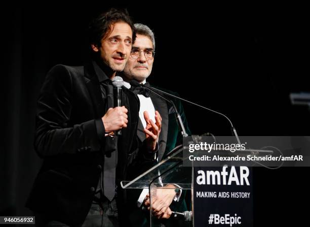 Adrien Brody and Felipe Diniz speak onstage during the 2018 amfAR gala Sao Paulo at the home of Dinho Diniz on April 13, 2018 in Sao Paulo, Brazil.