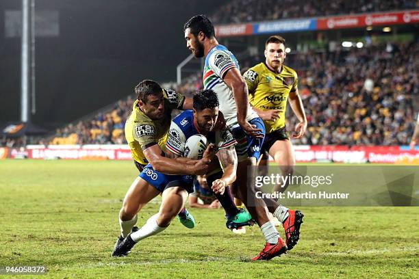 Shaun Johnson of the Warriors drives over to score a try in the tackle of Andrew McCullough of the Broncos during the round six NRL match between the...