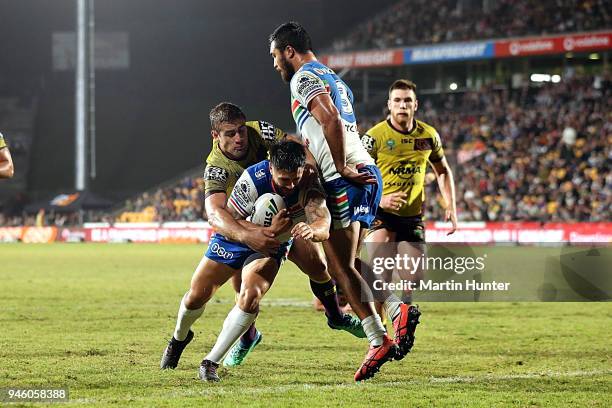 Shaun Johnson of the Warriors drives over to score a try in the tackle of Andrew McCullough of the Broncos during the round six NRL match between the...
