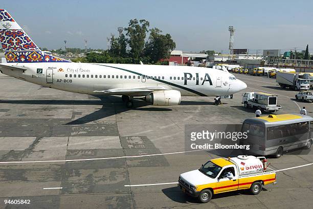 Shell airplane refuel van drives past a Pakistan International Airlines jet in Islamabad International Airport, Pakistan, on October 21, 2006.
