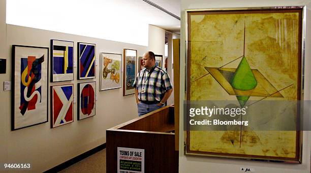 Kmart employee Tom Gallop looks over framed artwork during a preview of items to be auctioned from the Kmart corporate art collection at their former...