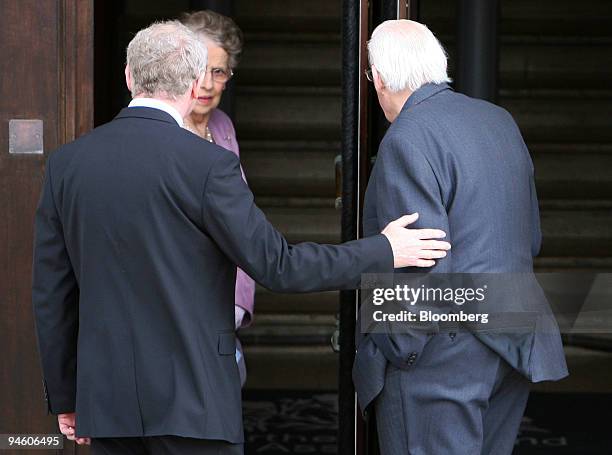 Martin McGuinness, Northern Ireland deputy first minister, left, helps Ian Paisley, first minister into the building at Stormont in Belfast, U.K.,...