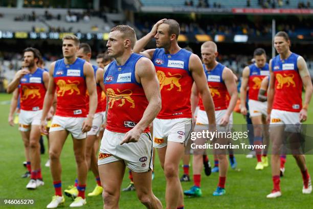 Dejected Brisbane Lions players walk off the M.C.G. After kicking just 2 goals during the round four AFL match between the Richmond Tigers and the...