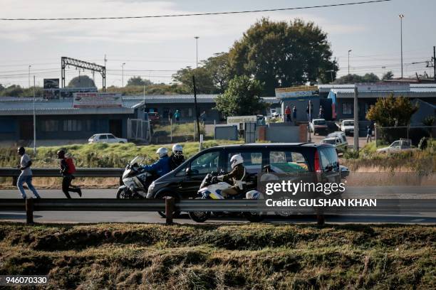 The motorcade transporting the coffin of Winnie Madikizela-Mandela drives through Soweto after leaving her home towards Orlando Stadium for a funeral...