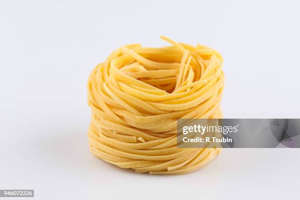 uncooked italian pasta - フェットチーネ ストックフォトと画像