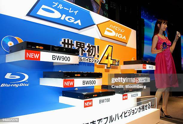 Model holds blue ray discs next to Matsushita Electric Industrial Co.'s new series of Panasonic DIGA blu-ray disc and high-definition DVD recorders...