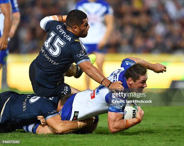 Josh Jackson of the Bulldogs is tackled by John Asiata of the Cowboys during the round six NRL match between the North Queensland Cowboys and the...