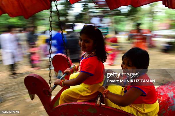 Bangladeshi children ride a merry-go-round as they celebrate the Bengali New Year or 'Pohela Boishakh' in Dhaka on April 14, 2018. The Bengali...