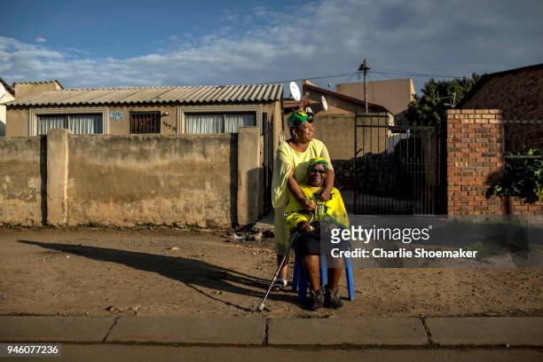 Flora Wesi who has lived on her street since 1952, waits with her neighbor Mapule Setle for the body of Winnie Mandela to pass by on it's way to the...