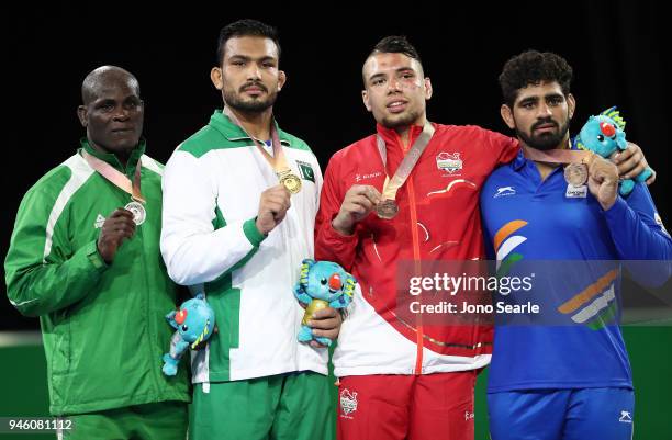 Silver Medalist Melvin Bibo of Nigeria, gold medalist Muhammad Inam of Pakistan and duel bronze medalists Eslami Syerus of England and Somveer of...