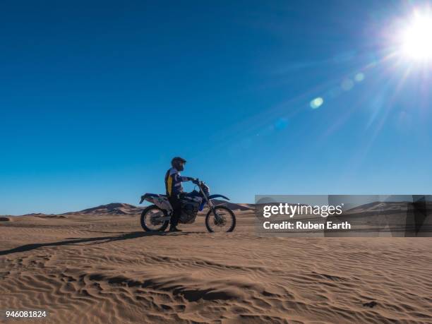 biker riding the sand dunes in the sahara desert - dakar stock pictures, royalty-free photos & images