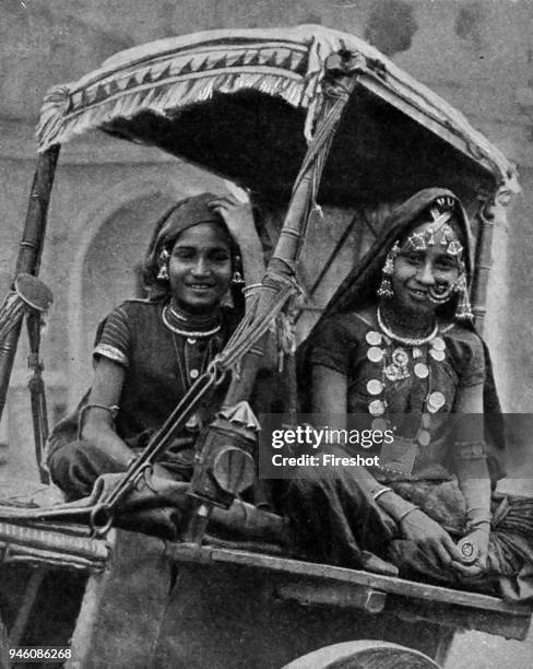 India 1900. Borne along in their decorative though not too confortable carriage, these Nautch girls display all the smiling animation with which they...