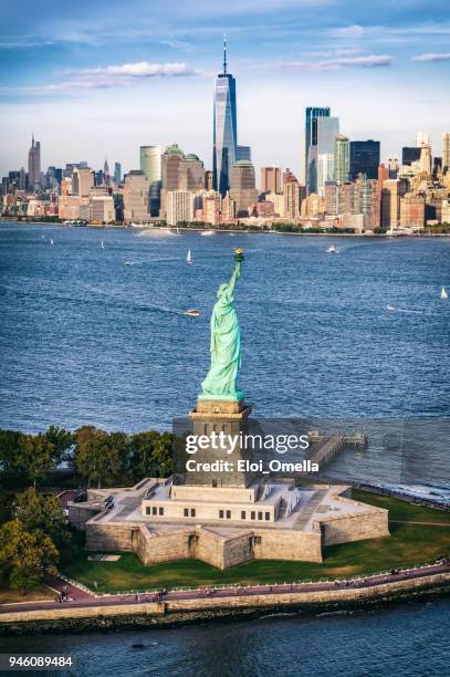 blick auf die freiheitsstatue vor der skyline von manhattan. new york. usa - insel liberty island stock-fotos und bilder