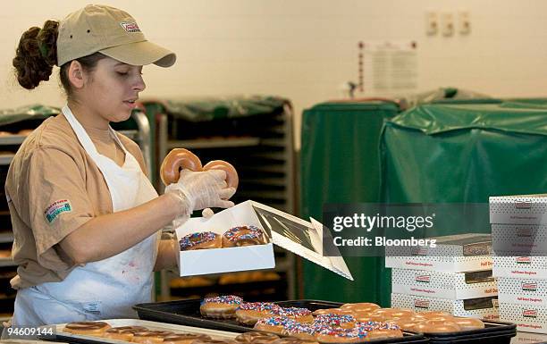 Employee Priscilla Araujo places doughnuts in a box at a Krispy Kreme store in Dedham, Massachusetts, Tuesday, June 13, 2006. Krispy Kreme Doughnuts...