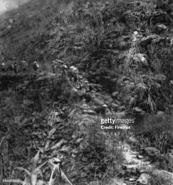 Battle of Diem Bien Phu 1954-Vietminh Dien Bien Phu conscripted labourers carring on shoulder and climbing up to slop.