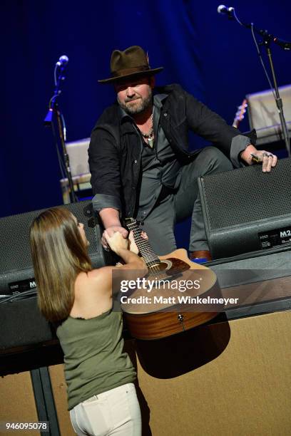 Lee Brice presents an autographed guitar to a special guest during ACM Stories, Songs & Stars: A Songwriter's Event Benefiting ACM Lifting Lives at...