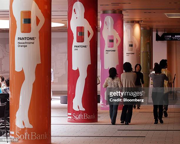 Pedestrians walk past a Softbank Corp. Sign in Tokyo, Japan, on Monday, May 7, 2007. Softbank Corp., Japan's third-biggest mobile-phone company,...