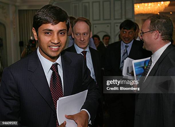 Aditya Mittal, president and chief financial officer of Mittal Steel Co., left, smiles as he arrives at a news conference, in London, June 13, 2006....