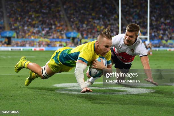 Thomas Connor of Australia dives over for a try under pressure from Tom Mitchell of England during the Rugby Sevens Men's Pool B match between...