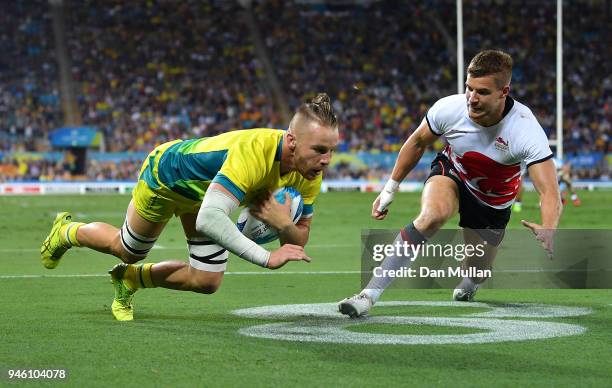 Thomas Connor of Australia dives over for a try under pressure from Tom Mitchell of England during the Rugby Sevens Men's Pool B match between...