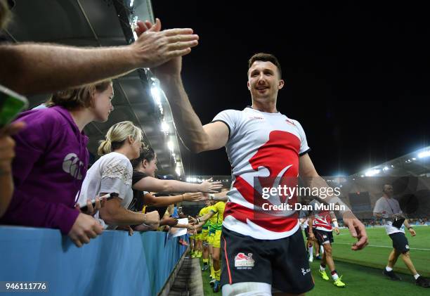 Alexander Davis of England high fives supporters as he leaves the field following his side's victory during the Rugby Sevens Men's Pool B match...