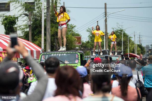 Pole dancers perform on the roofs of cars as they join the procession following the sedan chair carrying a statue of the goddess Mazu as it is...