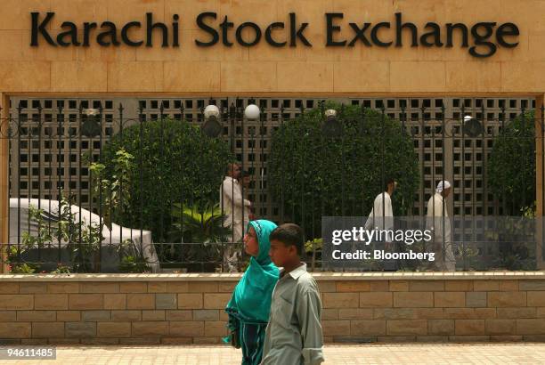 Pedestrians pass in front of the Karachi Stock Exchange in Karachi, Pakistan, on Monday, June 25, 2007. Pakistan's stocks may fall after television...
