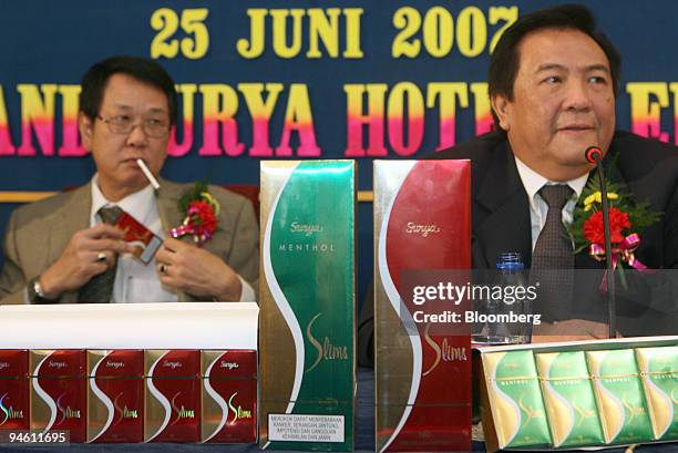 Heru Budiman, company director of PT Gudang Garam Tbk, left, and Widijanto, marketing director of PT Gudang Garam Tbk, right, sit behind a display of...