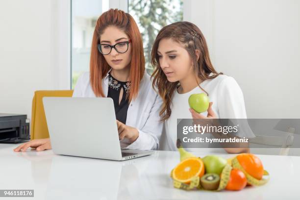 nutritionist showing diet plan on notebook - nutritionist stock pictures, royalty-free photos & images