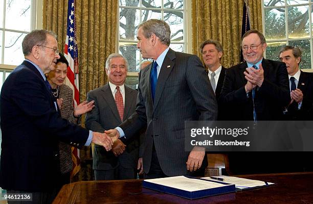 President George W. Bush, center, shakes hands with Senator Ted Stevens, a Republican from Alaska, as left to right, Senator Olympia Snowe, a...