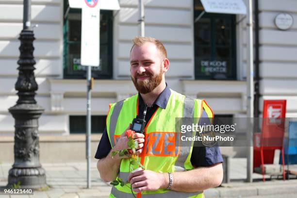 Bavarian police officer with a flower. Some hundreds of people joined the March for Science in Munich, Germany, on 14 April 2018. Among them there...