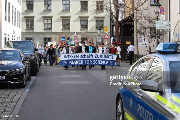 The activists marching with a police car in the foreground. Some hundreds of people joined the March for Science in Munich, Germany, on 14 April...