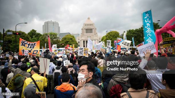 Protester holds a placard during a demonstration against Japan's Prime Minister Shinzo Abe after allegations of corruption, calling him to resign, on...