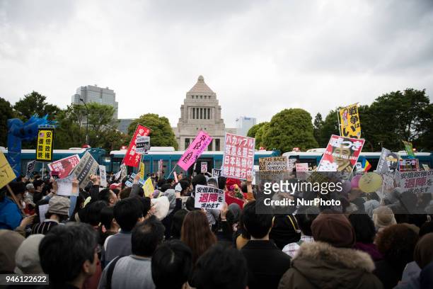 Protester holds a placard during a demonstration against the Japan's Prime Minister Shinzo Abe after allegations of corruption and calling him to...