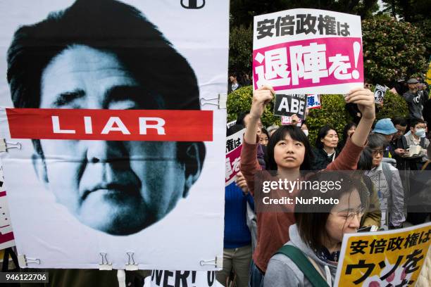 Protester holds a placard during a demonstration against the Japan's Prime Minister Shinzo Abe after allegations of corruption and calling him to...