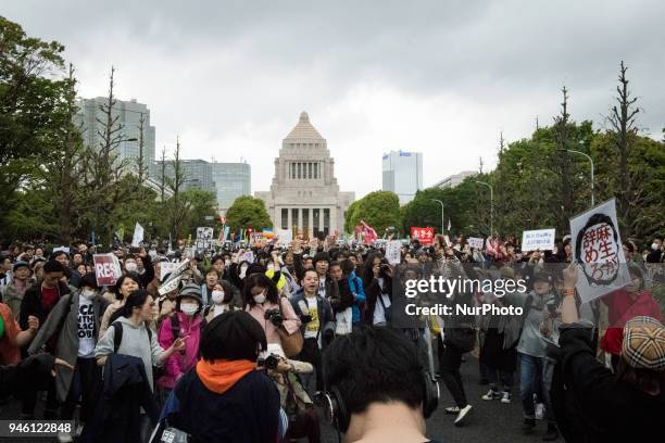 Protester holds a placard during a demonstration against Japan's Prime Minister Shinzo Abe after allegations of corruption, calling him to resign, on...