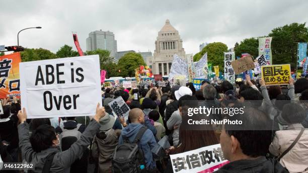 Protester holds a placard during a demonstration against Japan's Prime Minister Shinzo Abe after allegations of corruption, calling him to resign, on...