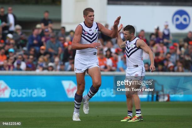 Aaron Sandilands of the Dockers celebrates a goal with teammate Hayden Ballantyne the ball out at the centre bounce during the round four AFL match...