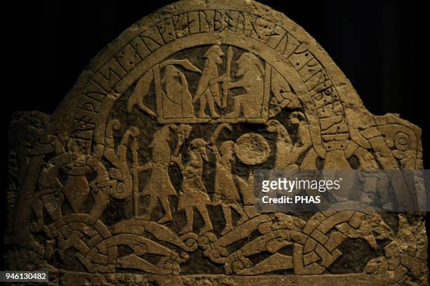 Stone engraved with the representation of the gods Odin, Thor and Frey at the bottom. At the top a sacrifice is shown to Odin. A man standing gives a...