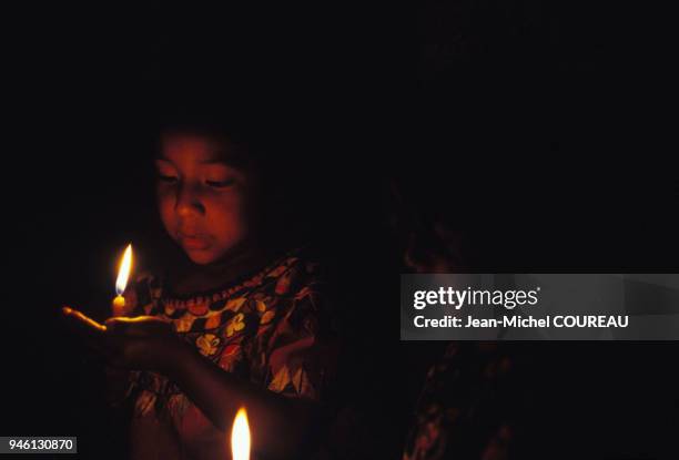 Procession de l'Escuela de Cristo dans la ville d'Antigua durant la Semaine Sainte, jeune fille accompagnant la procession avec des bougies,...
