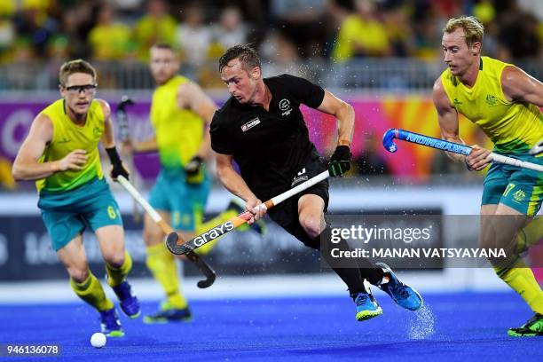Hugo Inglis of New Zealand vies for the ball with Australia's Matthew Dawson and Aran Zalewski during their men's field hockey gold medal match of...