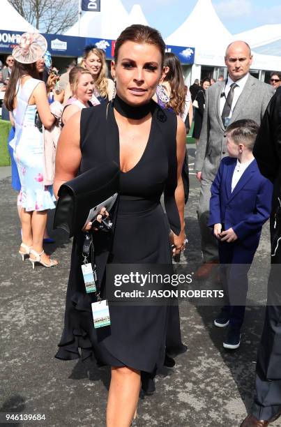 Coleen Rooney, wife of Everton's football player Wayne Rooney, arrives to attend the final day of the Grand National Festival horse race meeting at...