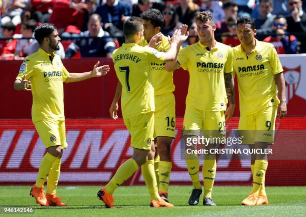 Villarreal's Spanish midfielder Daniel Raba is congratulated by teammates for scoring a goal during the Spanish league footbal match between Sevilla...