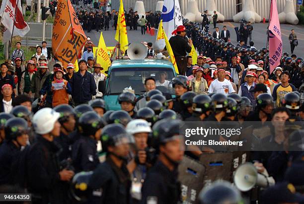 Riot police block the path of demonstrating farmers during a rally against the U.S. And South Korea's Free Trade Agreement meeting in Jeju, South...