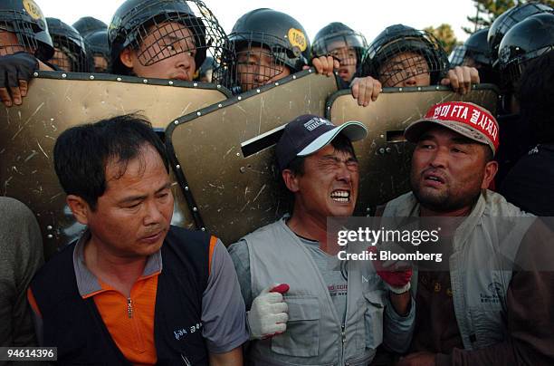 Riot police block the path of demonstrating farmers during a rally against the U.S. And South Korea's Free Trade Agreement meeting in Jeju, South...